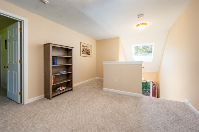 spare room featuring baseboards and light colored carpet