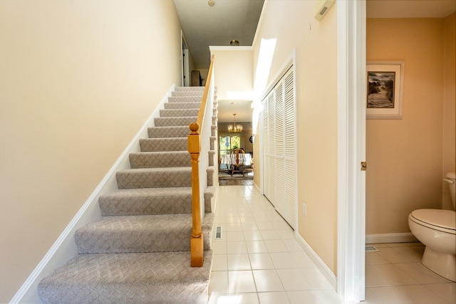 stairway with tile patterned floors and a chandelier