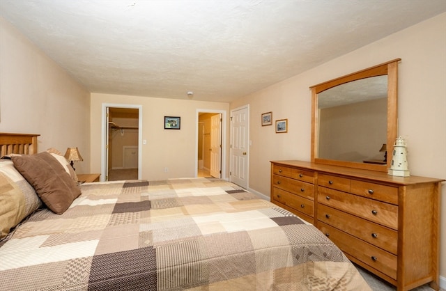 bedroom with a textured ceiling, light colored carpet, and baseboards