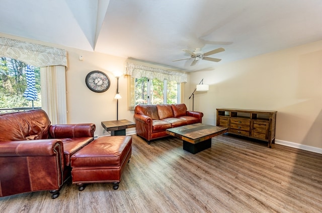 living area with ceiling fan, baseboards, and wood finished floors