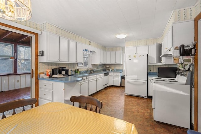 kitchen with white appliances, white cabinetry, and wallpapered walls