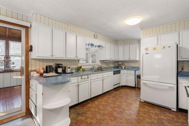 kitchen with white appliances, white cabinets, open shelves, dark countertops, and wallpapered walls