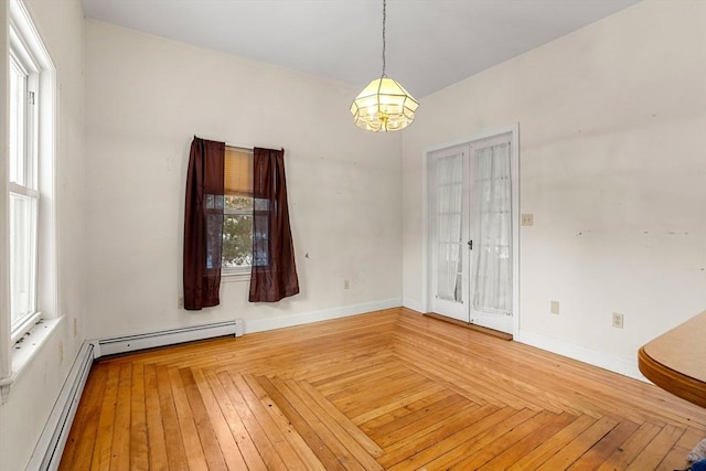 unfurnished room featuring an inviting chandelier, baseboards, a baseboard heating unit, and baseboard heating