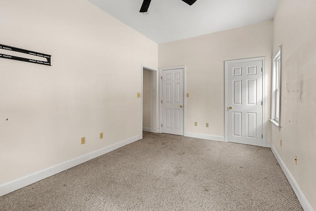 unfurnished bedroom featuring a ceiling fan, light colored carpet, and baseboards