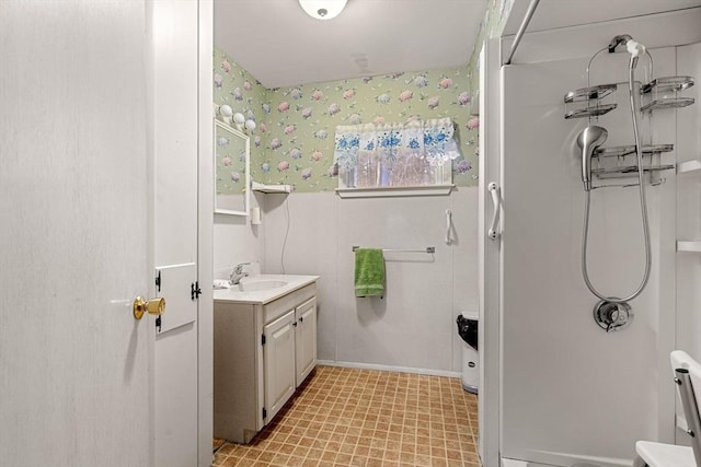 bathroom with vanity and wallpapered walls