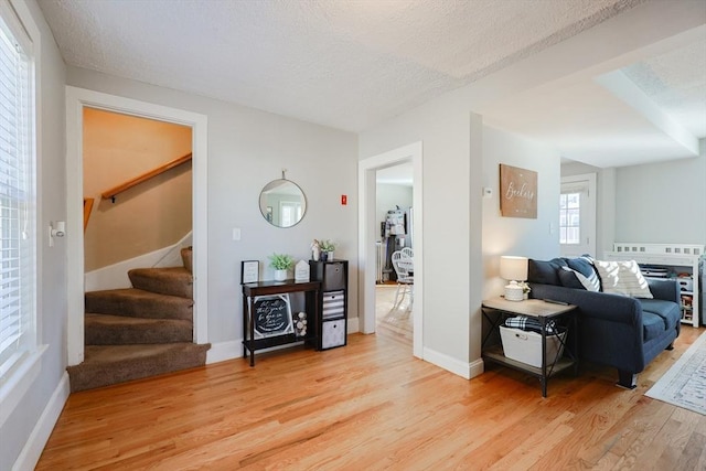 living room with a textured ceiling and wood-type flooring