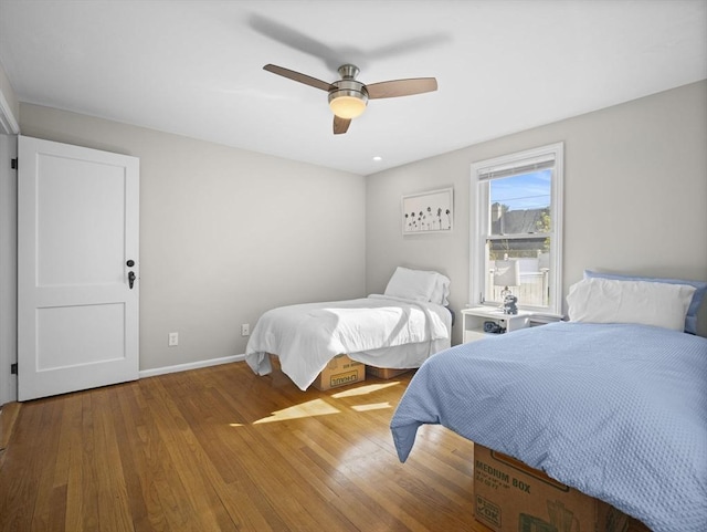 bedroom with baseboards, ceiling fan, and wood finished floors