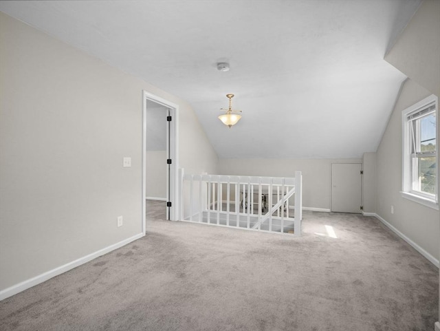 additional living space featuring carpet floors, baseboards, and lofted ceiling