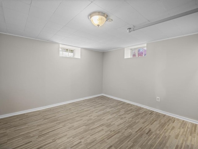 basement with baseboards, wood finished floors, and a wealth of natural light