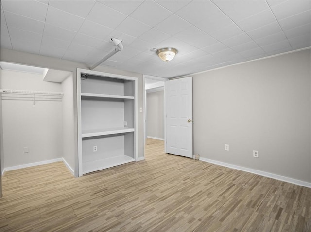 unfurnished bedroom featuring baseboards, wood finished floors, and a closet