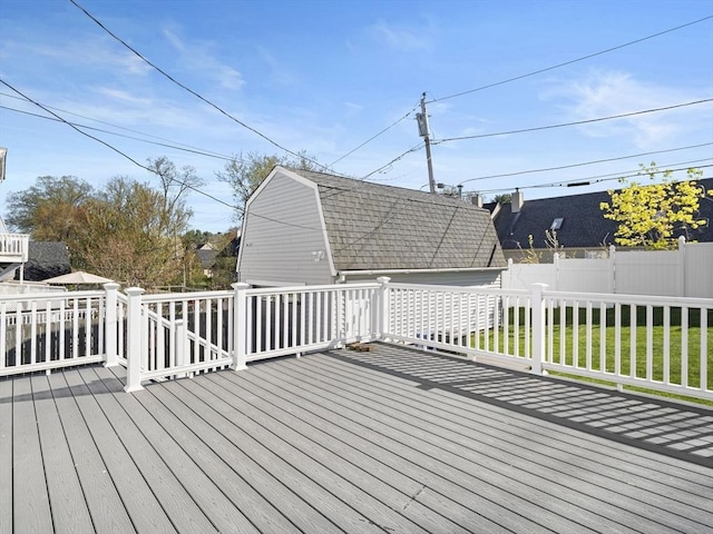 wooden terrace featuring a yard and fence