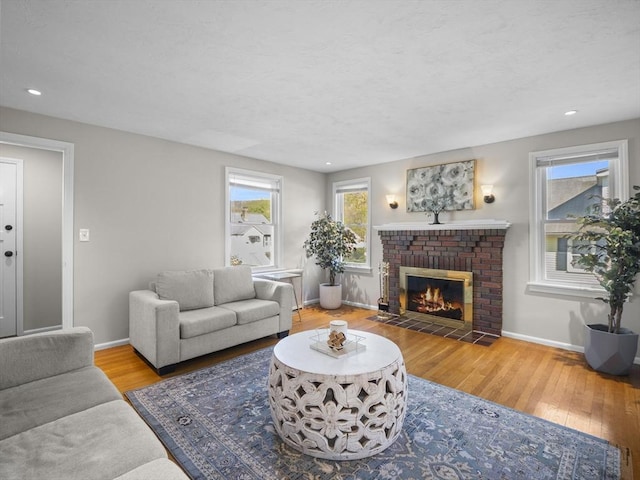 living room featuring recessed lighting, baseboards, wood finished floors, and a fireplace
