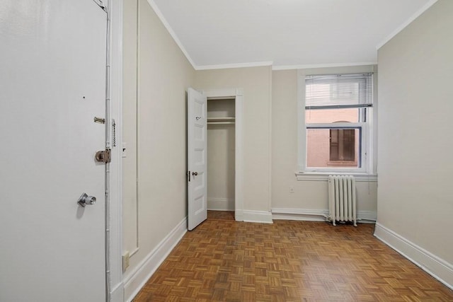 unfurnished bedroom featuring radiator, ornamental molding, baseboards, and a closet