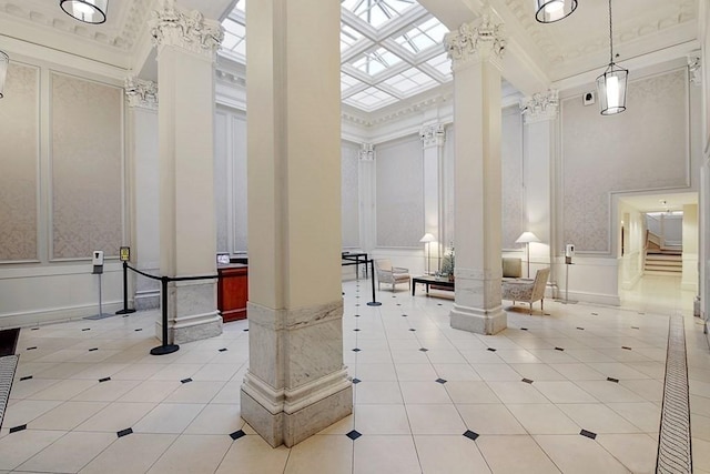 building lobby with a wainscoted wall, a high ceiling, and ornamental molding