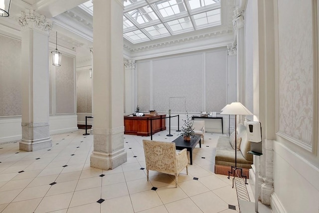 building lobby featuring a decorative wall, ornamental molding, and wainscoting