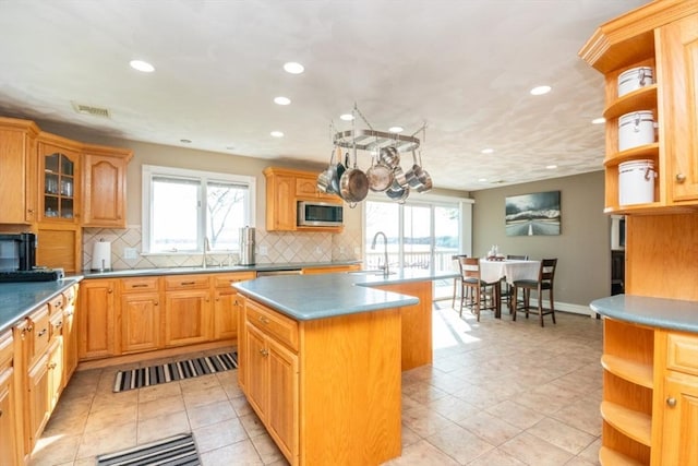 87 Lewis Point Rd, Bourne, MA 02532 - kitchen featuring open shelves, stainless steel microwave, a center island with sink, recessed lighting, and a sink