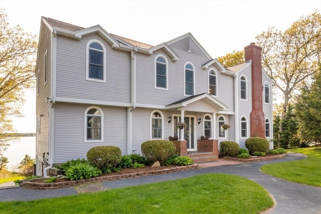 87 Lewis Point Rd, Bourne, MA 02532 - view of front facade featuring a chimney and a front yard
