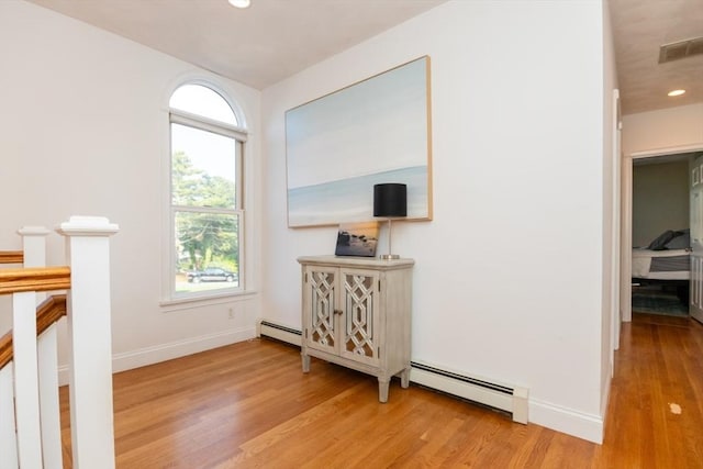 87 Lewis Point Rd, Bourne, MA 02532 - hallway with light wood-style flooring, a baseboard radiator, baseboards, recessed lighting, and an upstairs landing