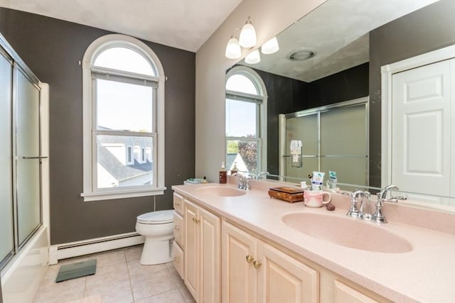87 Lewis Point Rd, Bourne, MA 02532 - bathroom featuring baseboard heating, tile patterned flooring, toilet, double vanity, and combined bath / shower with glass door