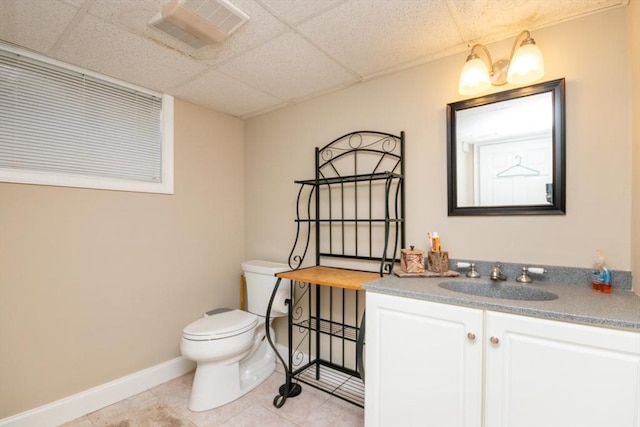 87 Lewis Point Rd, Bourne, MA 02532 - half bath featuring toilet, vanity, baseboards, tile patterned flooring, and a paneled ceiling