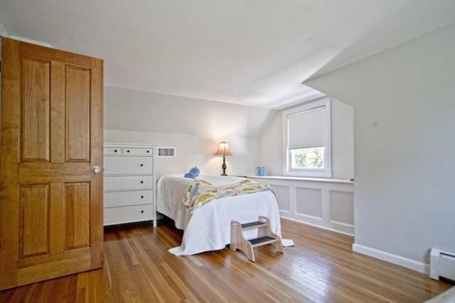 58 Lakeshore Ave, Beverly, MA 01915 - bedroom with a baseboard heating unit, wood finished floors, and lofted ceiling