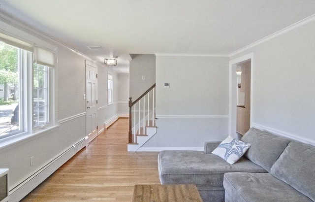 58 Lakeshore Ave, Beverly, MA 01915 - living room featuring a baseboard heating unit, crown molding, light wood-style flooring, and stairs