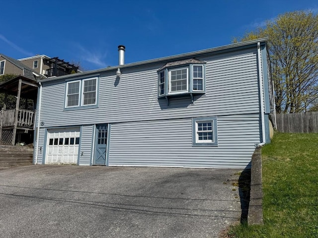 exterior space featuring fence, driveway, and a garage