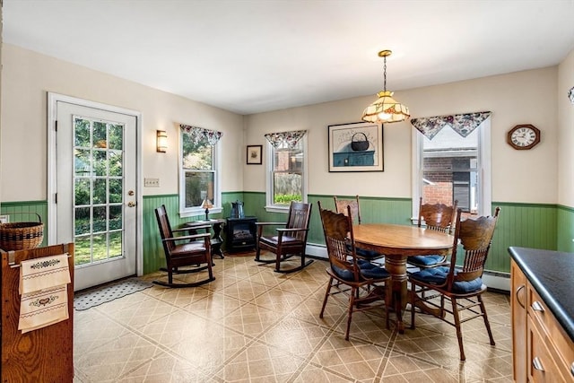 dining area with a baseboard radiator and a wainscoted wall