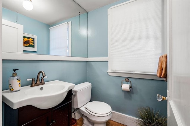 bathroom featuring vanity, baseboards, and toilet