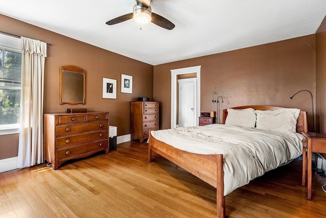 bedroom with baseboards, ceiling fan, and light wood finished floors