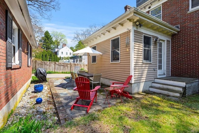 exterior space featuring fence, a chimney, and a patio area