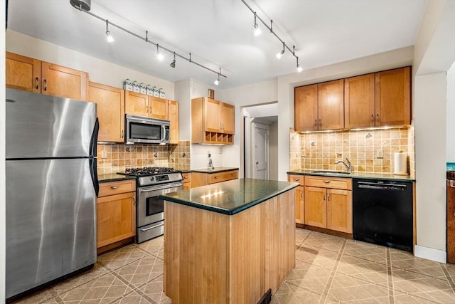 kitchen with a kitchen island, dark countertops, appliances with stainless steel finishes, and a sink