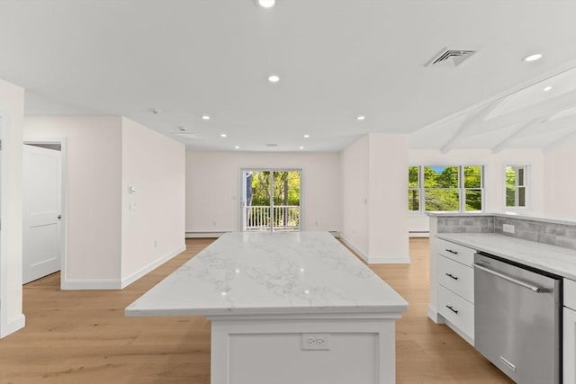 kitchen featuring stainless steel dishwasher, light wood finished floors, baseboards, recessed lighting, and beamed ceiling