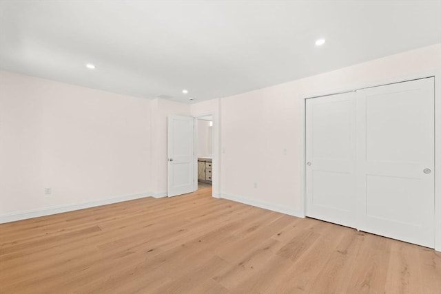 unfurnished bedroom with light wood-type flooring, baseboards, recessed lighting, and a closet