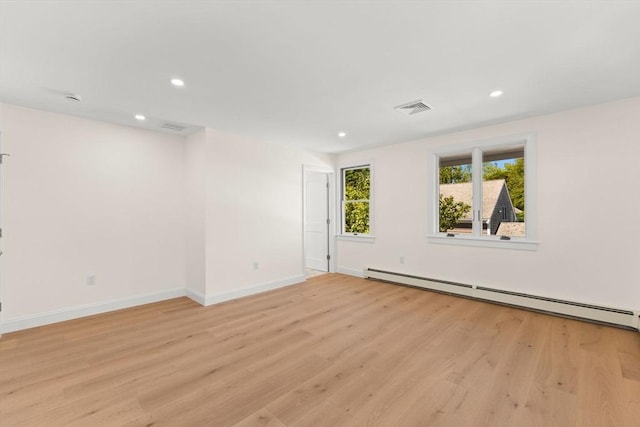 unfurnished room featuring baseboard heating, light wood finished floors, recessed lighting, and baseboards