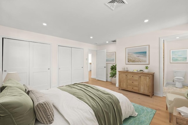 bedroom featuring two closets, light wood-type flooring, recessed lighting, baseboards, and ensuite bath