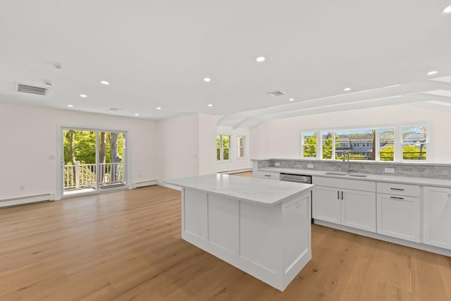 kitchen with a sink, open floor plan, healthy amount of natural light, a kitchen island, and recessed lighting