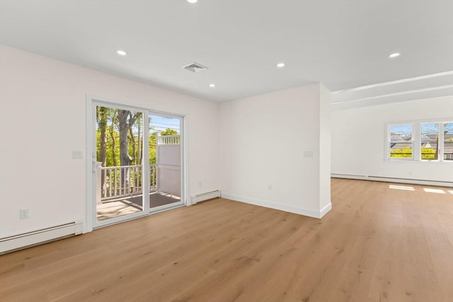 spare room with a baseboard heating unit, light wood finished floors, healthy amount of natural light, and recessed lighting