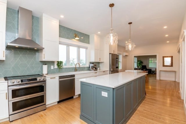 15 Dundee Rd, Quincy, MA 02171 - kitchen featuring appliances with stainless steel finishes, wall chimney range hood, white cabinetry, tasteful backsplash, and light countertops