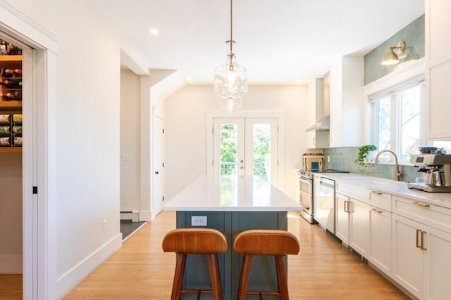 15 Dundee Rd, Quincy, MA 02171 - kitchen with wall chimney exhaust hood, dishwasher, a kitchen bar, light wood-type flooring, and light countertops