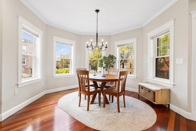 dining area featuring ornamental molding, hardwood / wood-style floors, and a chandelier