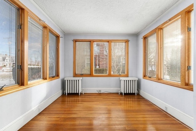 unfurnished sunroom featuring radiator and a healthy amount of sunlight