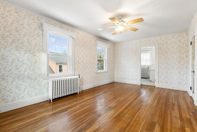 interior space featuring ceiling fan, wood-type flooring, and radiator heating unit