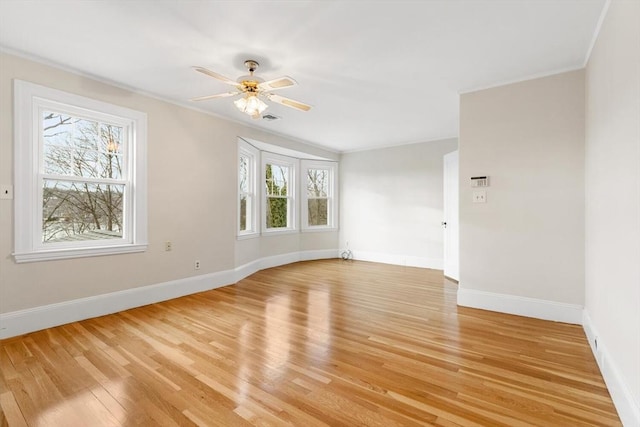 spare room with ceiling fan, vaulted ceiling, a wealth of natural light, and light hardwood / wood-style floors