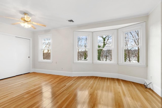 empty room with ceiling fan, light hardwood / wood-style flooring, and ornamental molding