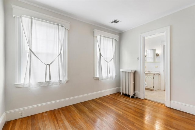 empty room with radiator and hardwood / wood-style floors