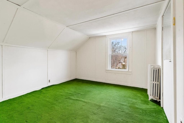 additional living space featuring carpet floors, radiator, and vaulted ceiling