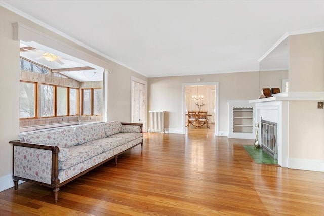 living room with vaulted ceiling, an inviting chandelier, crown molding, and hardwood / wood-style floors