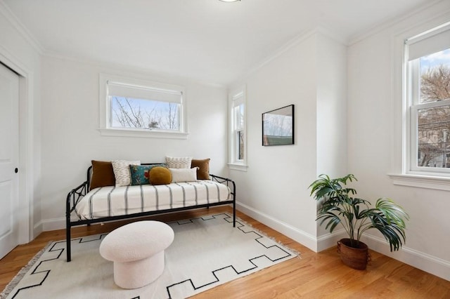 bedroom featuring ornamental molding, baseboards, and wood finished floors