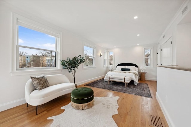 bedroom featuring visible vents, baseboards, and wood finished floors